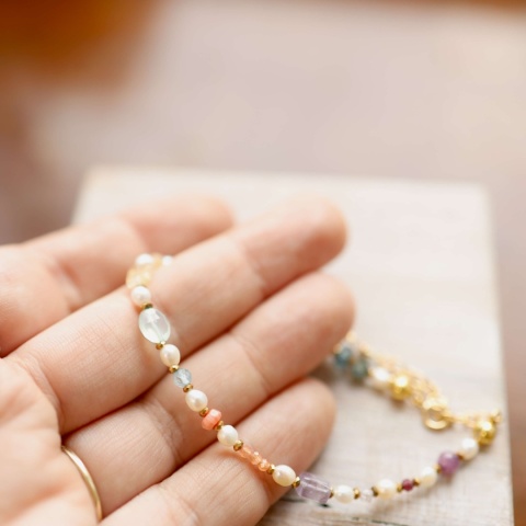 Delikatna bransoletka z perłą i hematytem, wykonana na przezroczystej żyłce ze złoconym srebrnym zapięciem.