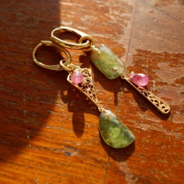 Złocone srebrne kolczyki z zielonymi szafirami i kroplami rubinu na angielskim zapięciu na drewnianym tle