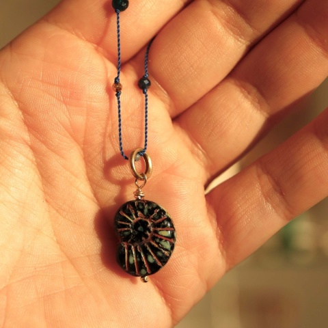 Zbliżenie na zawieszkę w kształcie amonitu