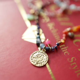 Zbliżenie na zawieszkę monetkę i kamienie naturalne w supełkowanym naszyjniku handmade