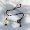 Ręcznie wykonany naszyjnik z kianitu, koralu i pozłacanego srebra na białym tle.