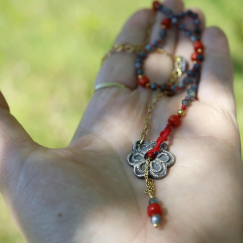 Srebrny złocony naszyjnik z naturalnymi kamienami na dłoni