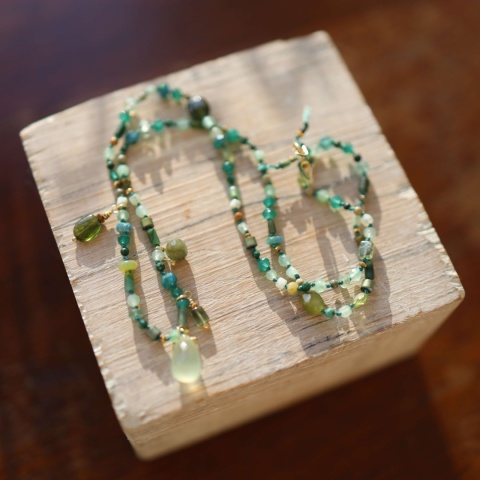Naszyjnik z naturalnych, zielonych kamieni, supełkowanych ręcznie na nylonowej nici, z zawieszką z frenitu na drewnianym tle