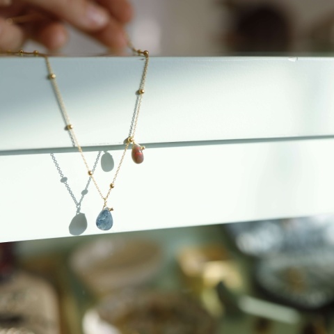 Elegancki naszyjnik z drobnymi kuleczkami i zawieszkami z jasnoniebieskiego akwamarynu i ciemnego opala.