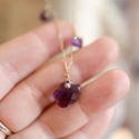 Naszyjnik z naturalną perłą i ametystem na tle ręki