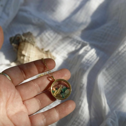 Elegancki naszyjnik z pozłacanego srebra i minerałów sfotografowany na ręce