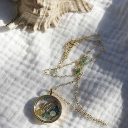 Naszyjnik z pozłacanego srebra z sekretnikiem i naturalnymi kamieniami na białym tle.