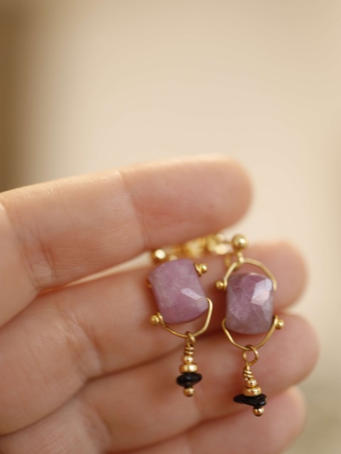 zblizenie na rubinowe kolczyki na dłoni.